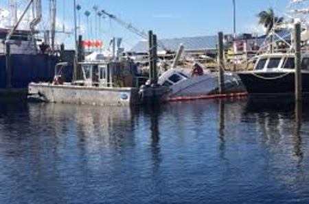 A boat is docked in the water near other boats.